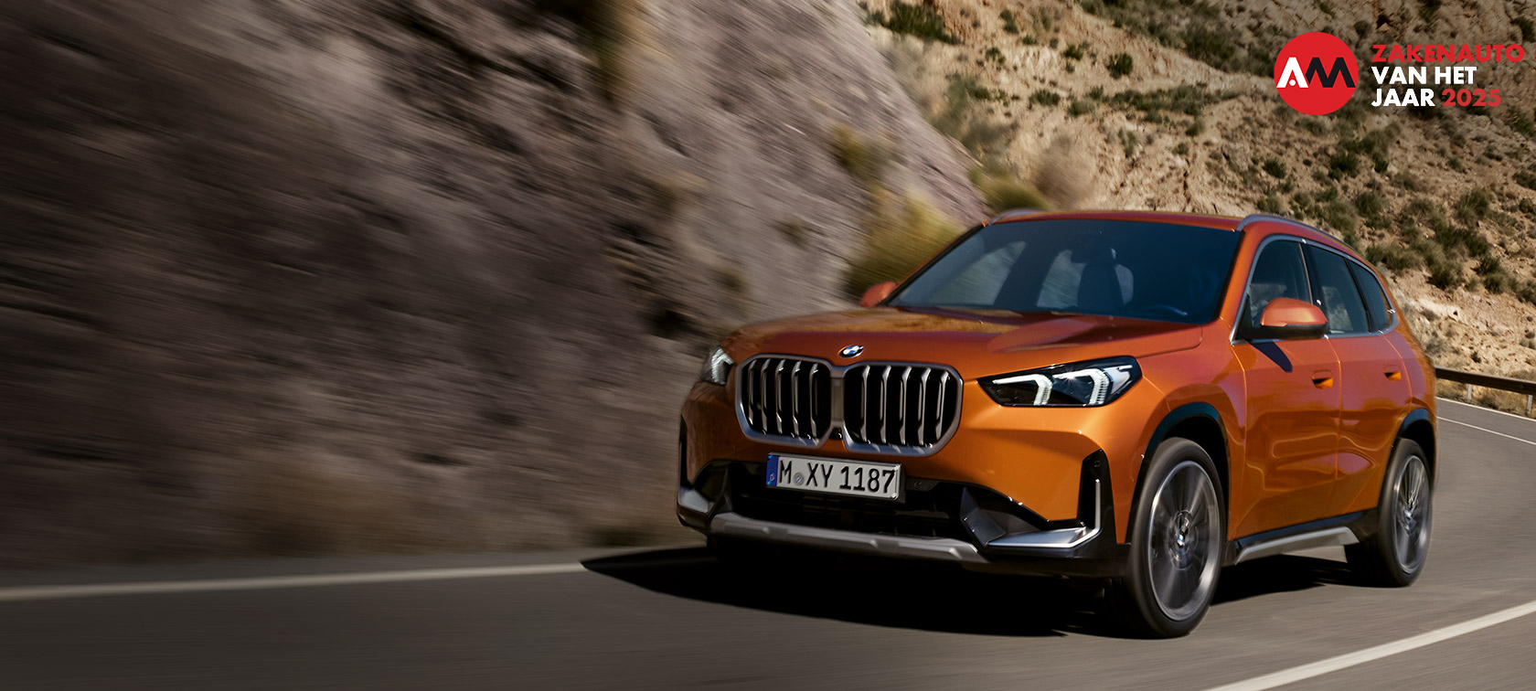 BMW X1 U11 xLine Utah Orange metallic driekwart vooraanzicht rijdend op buitenweg